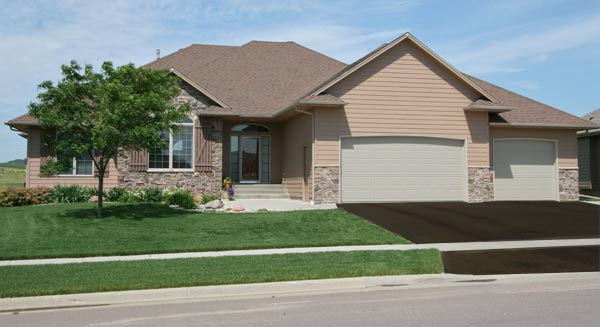 house with healthy grass, driveway seal and landscaping